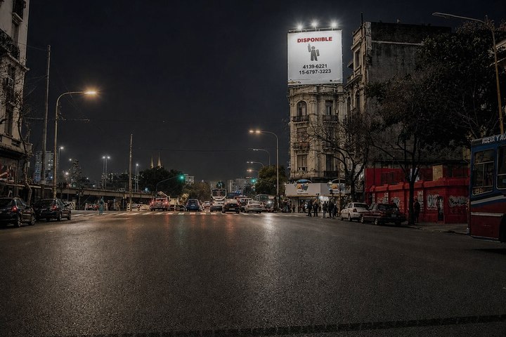 Cartel de Mentor iluminado de noche sobre una avenida